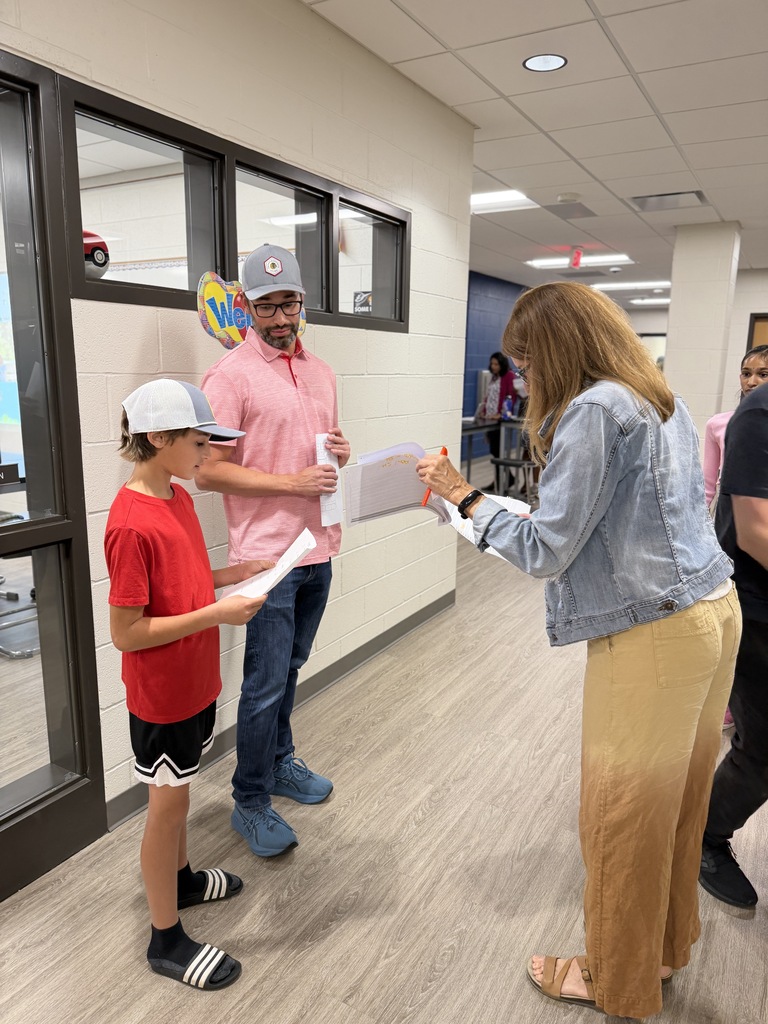 Father and son standing with teacher.