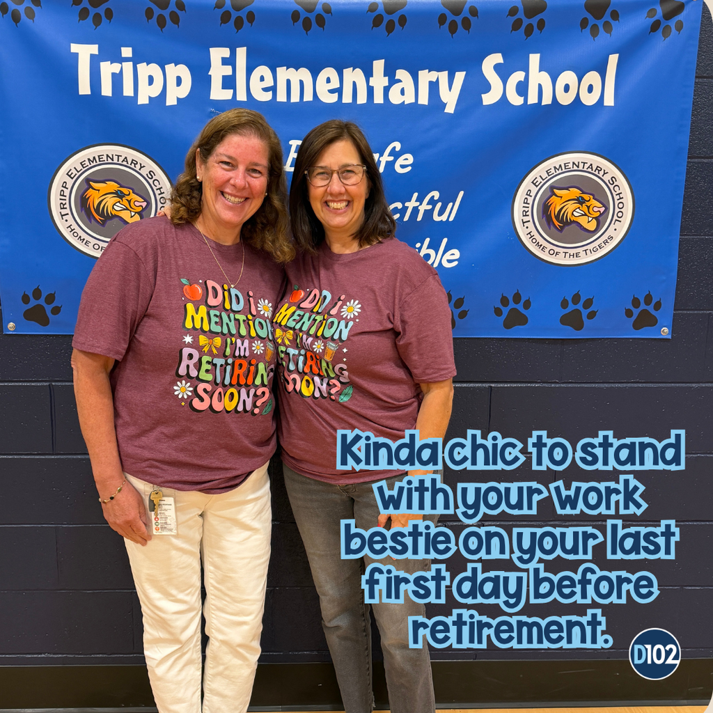 Photo of 2 teachers standing together in matching shirts.