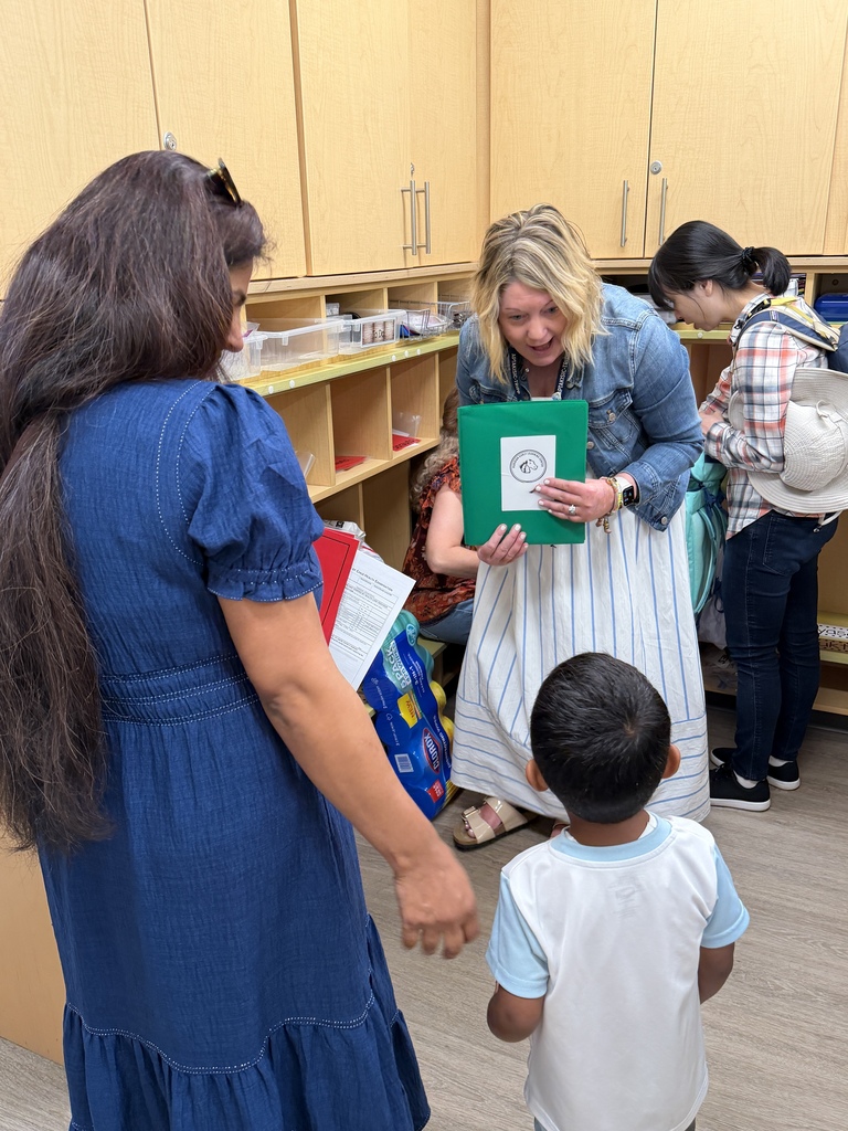 Student standing with his mom and teacher.