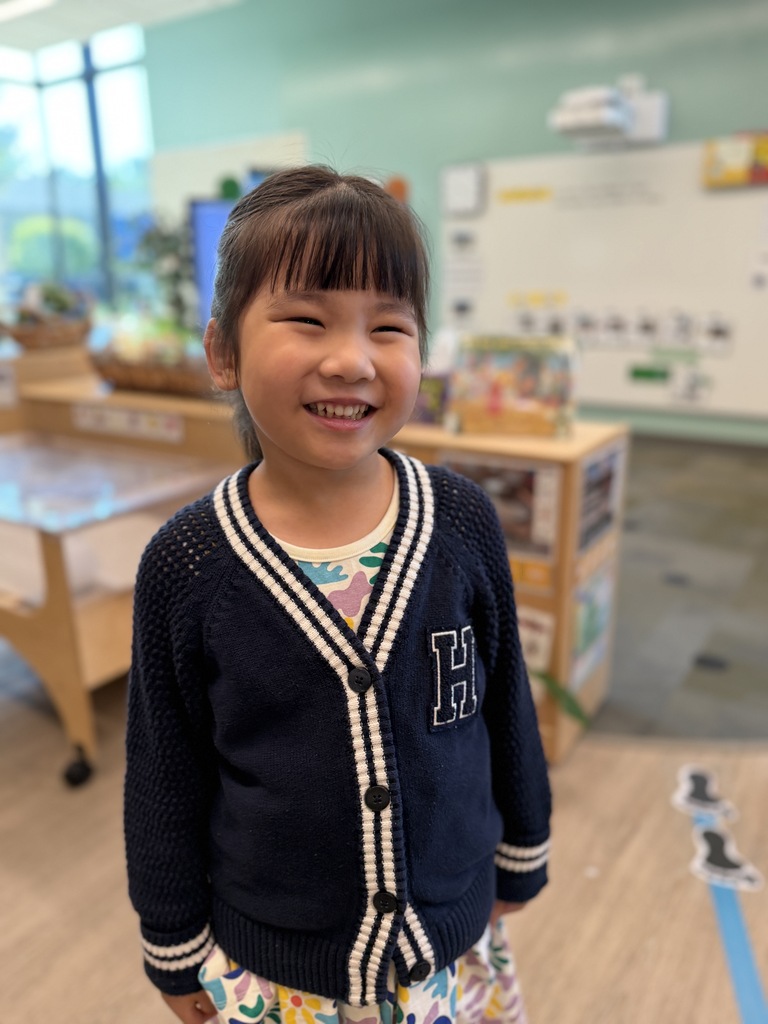 Girl smiling in her new classroom.