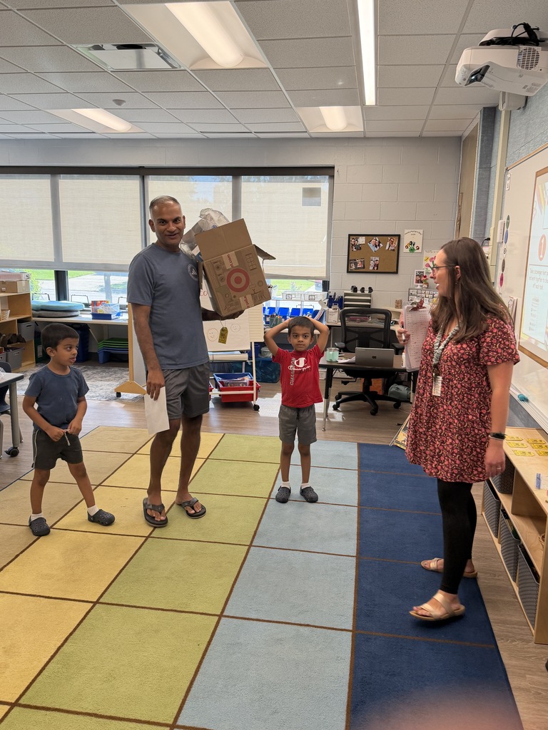 Teacher standing with a dad and two students. 