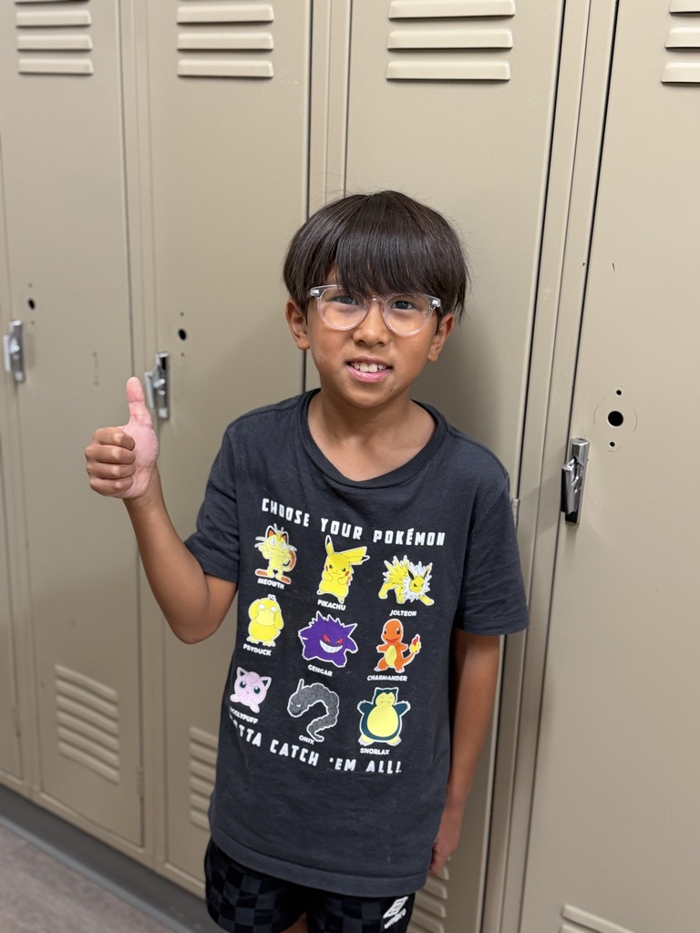 STudent giving a thumbs up by a locker. 