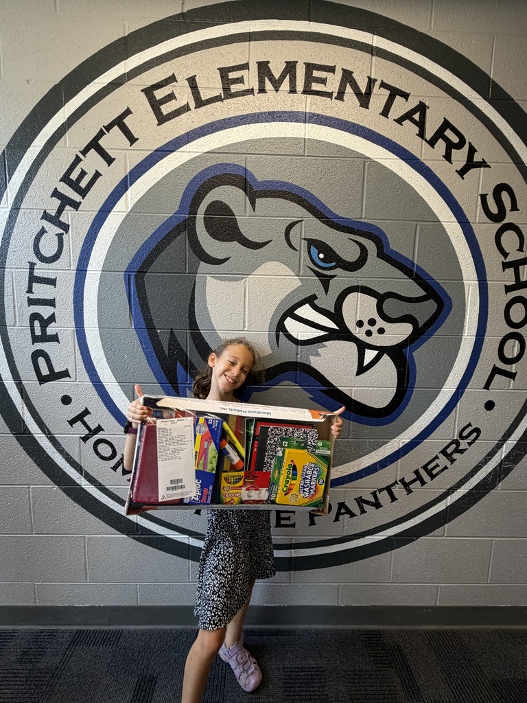 STudent holding supplies by a panther decal. 