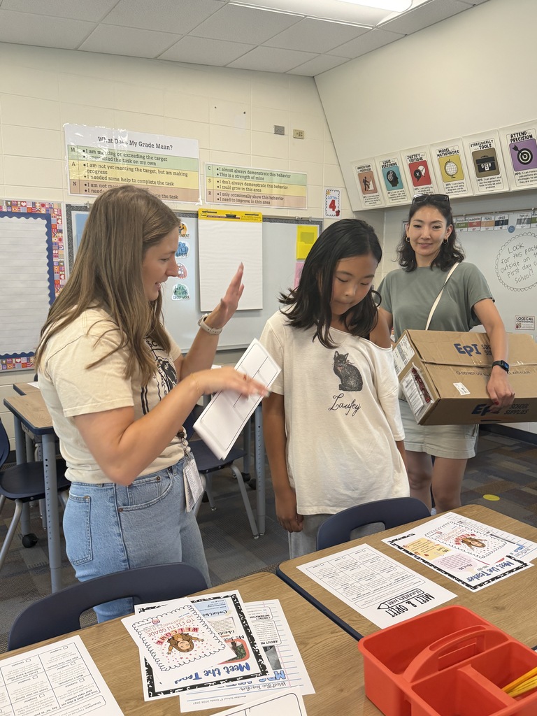 Teacher showing a student her desk. 