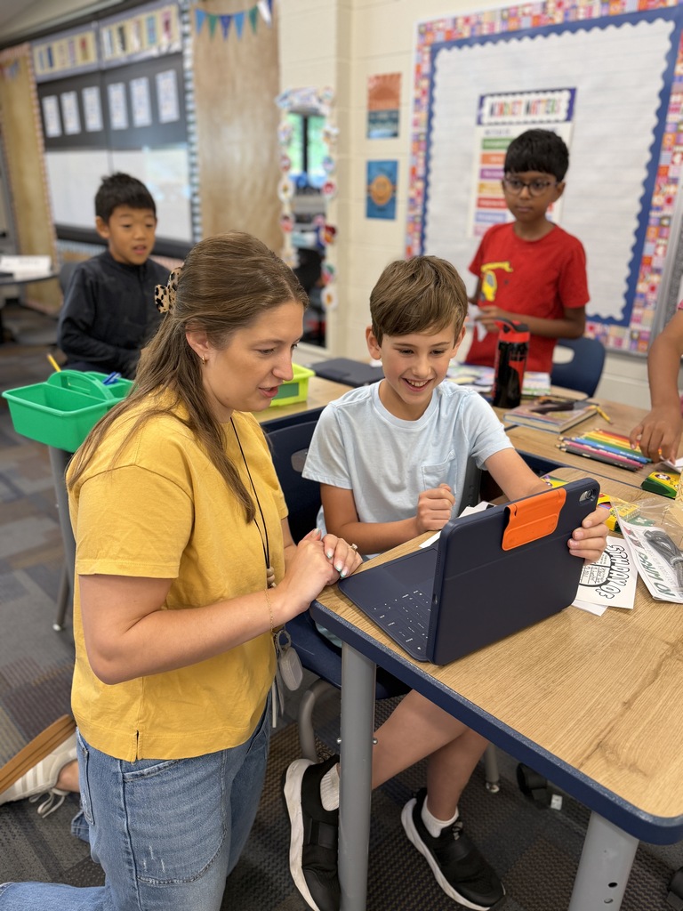 Ms. J looking at an ipad with a student.