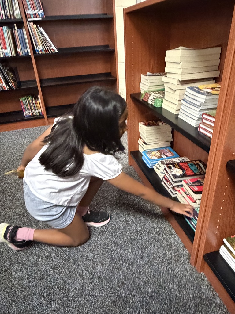 Student pulling a book from the shelf.