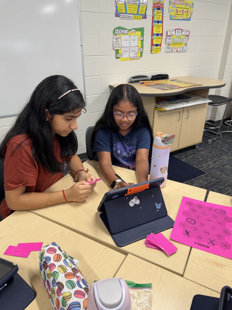 2 girls writing on their ipads.