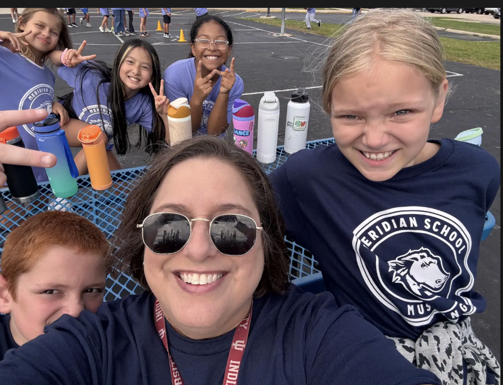 Teacher with students smiling for a selfie.