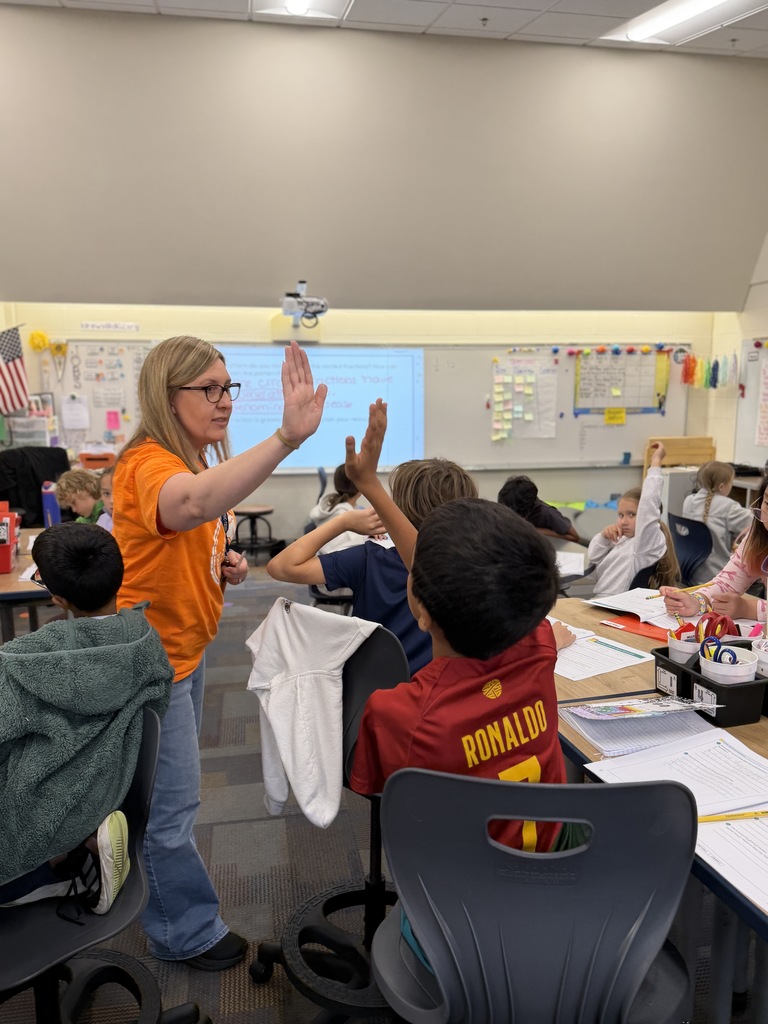Teacher gives a high-five to a student.