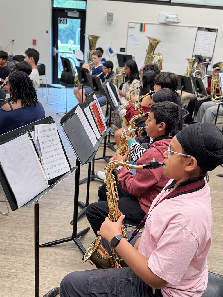 Students sitting down playing music.