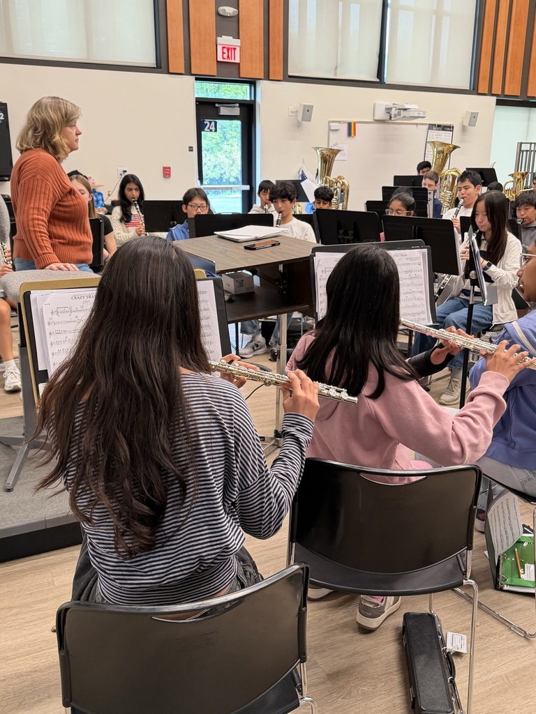 Students playing instruments with music sheets in front of them.