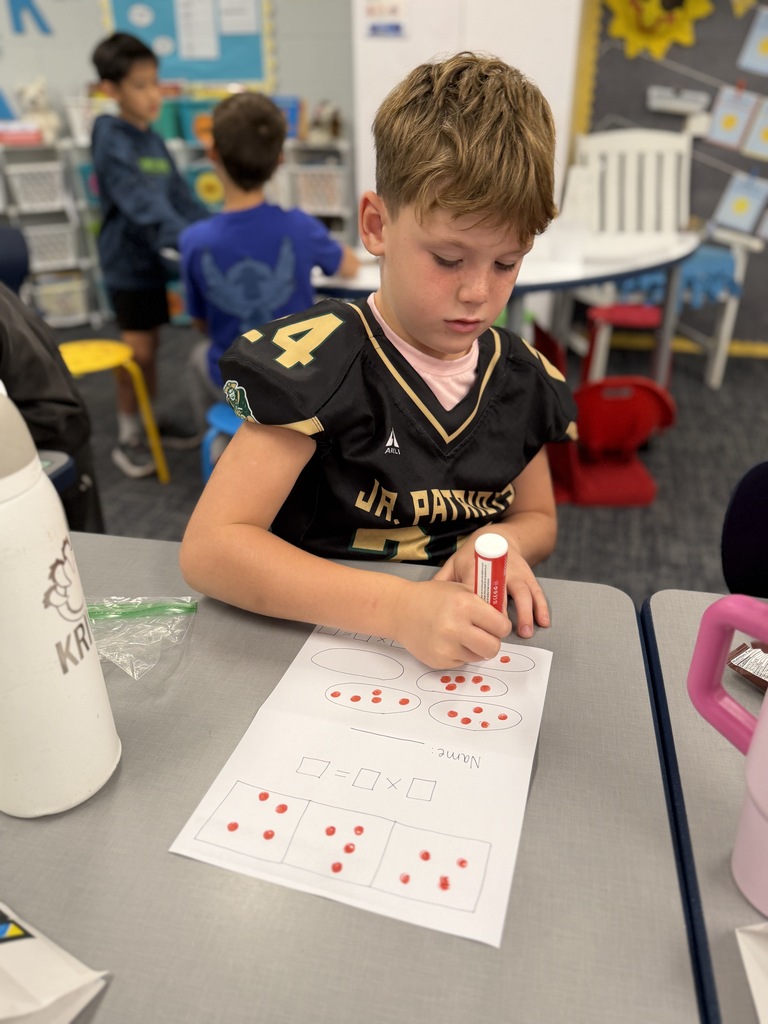 One student working with dot painter and paper.