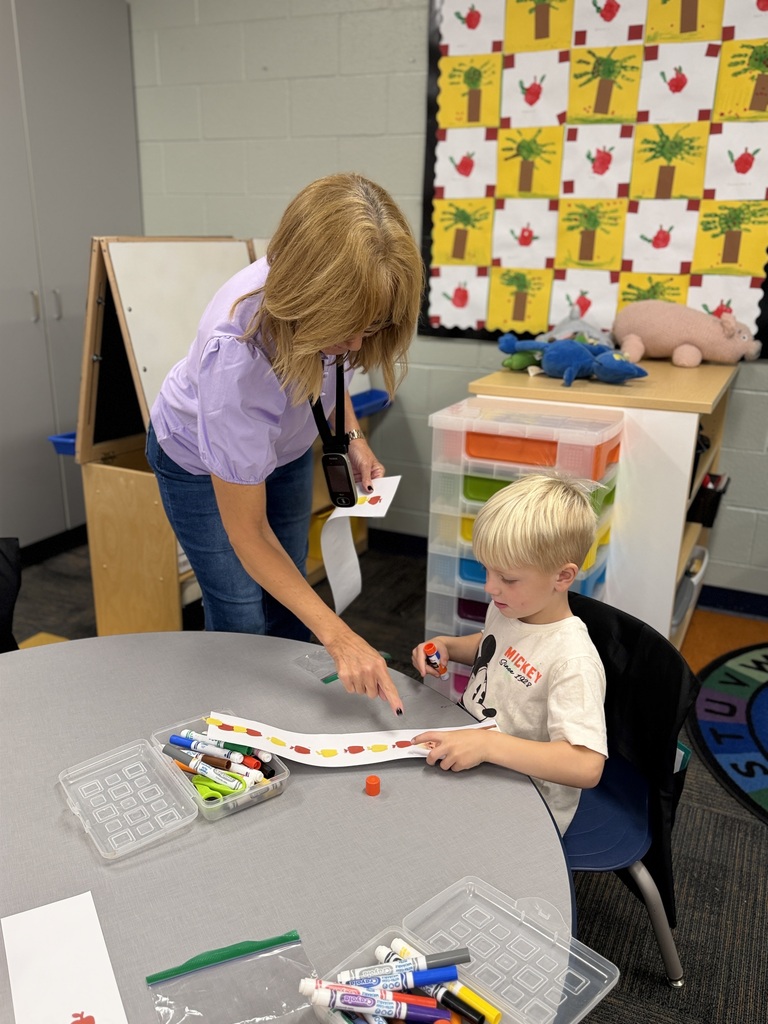 Mrs. I helps a student with his project.