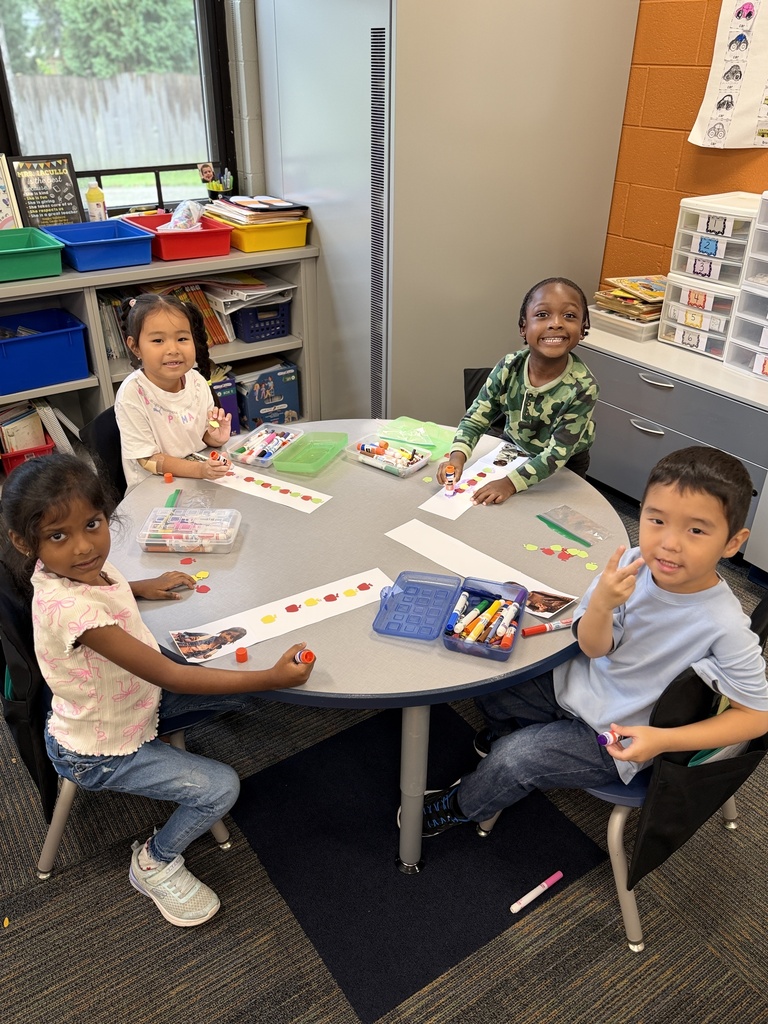 4 students sitting at a table with their craft.