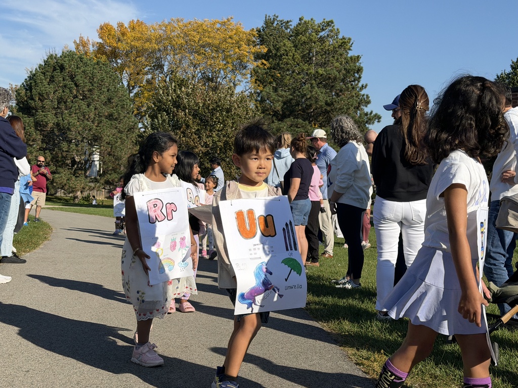 2 students walking with their posters. 