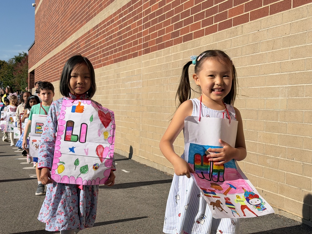 2 girls walking with their posters. 