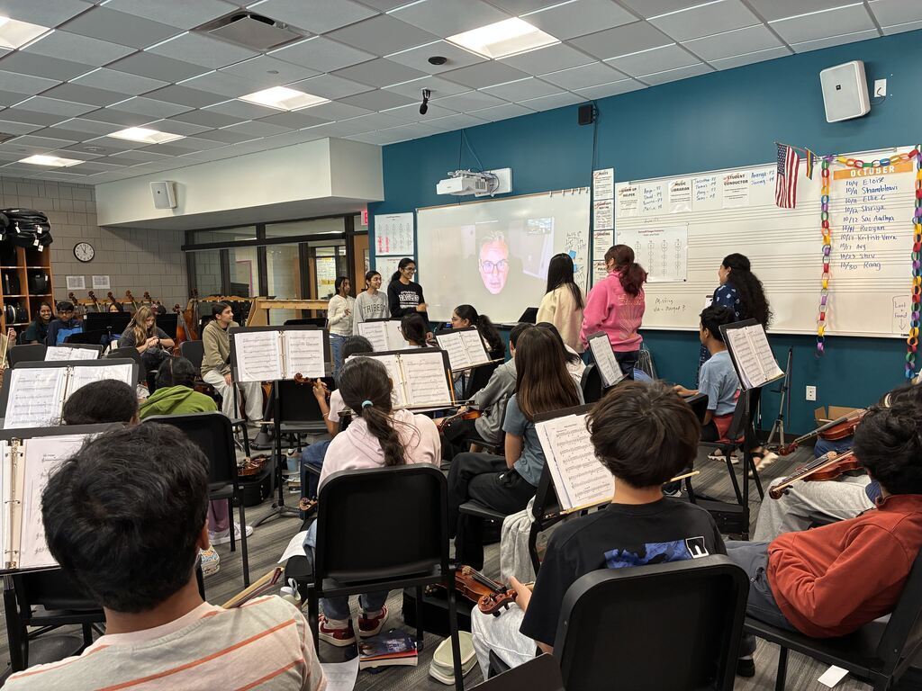 Students sitting in their seats with music stands in front of them.