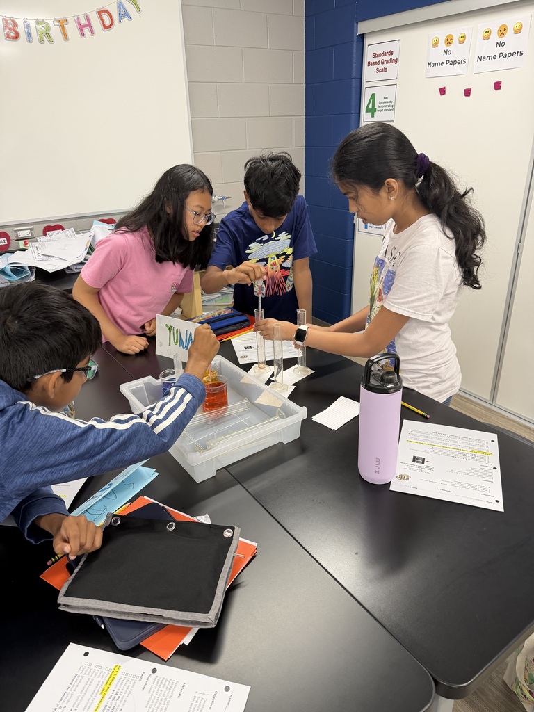 Students working together on a lab project at tables.