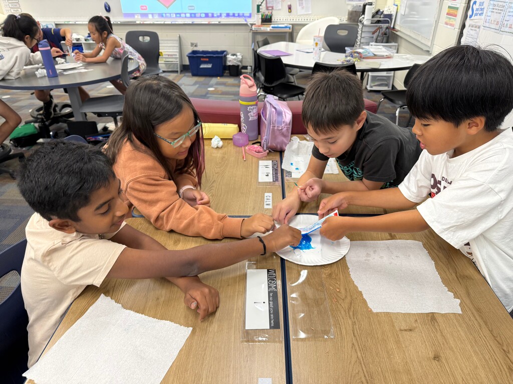Students squeezing toothpaste in a tube.
