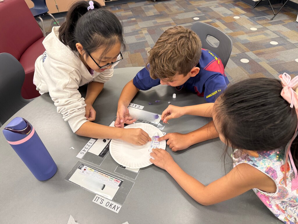 STudents trying to get toothpaste back in a container.