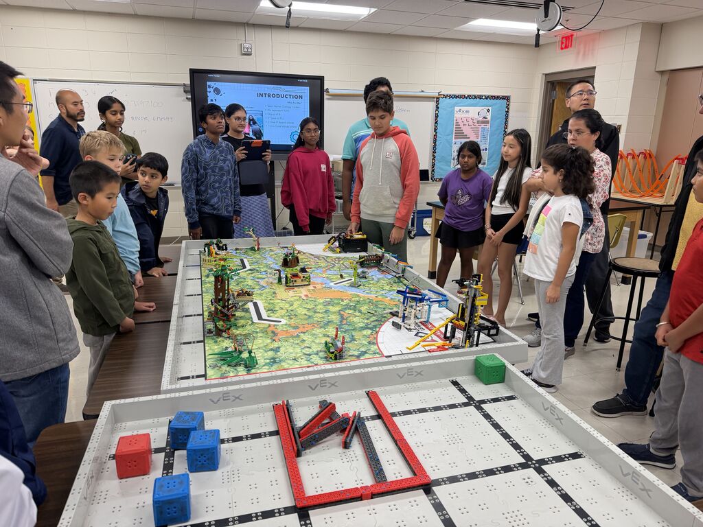 Students standing around a table with LEGO robots.