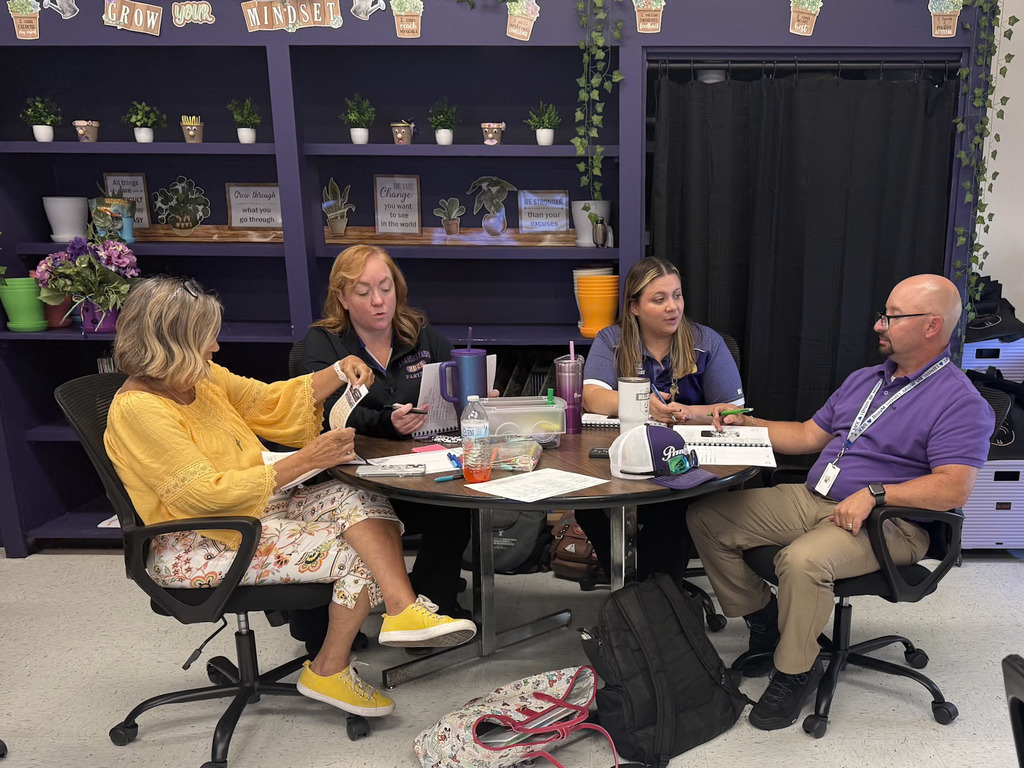Group of adults sitting around a table with notebooks