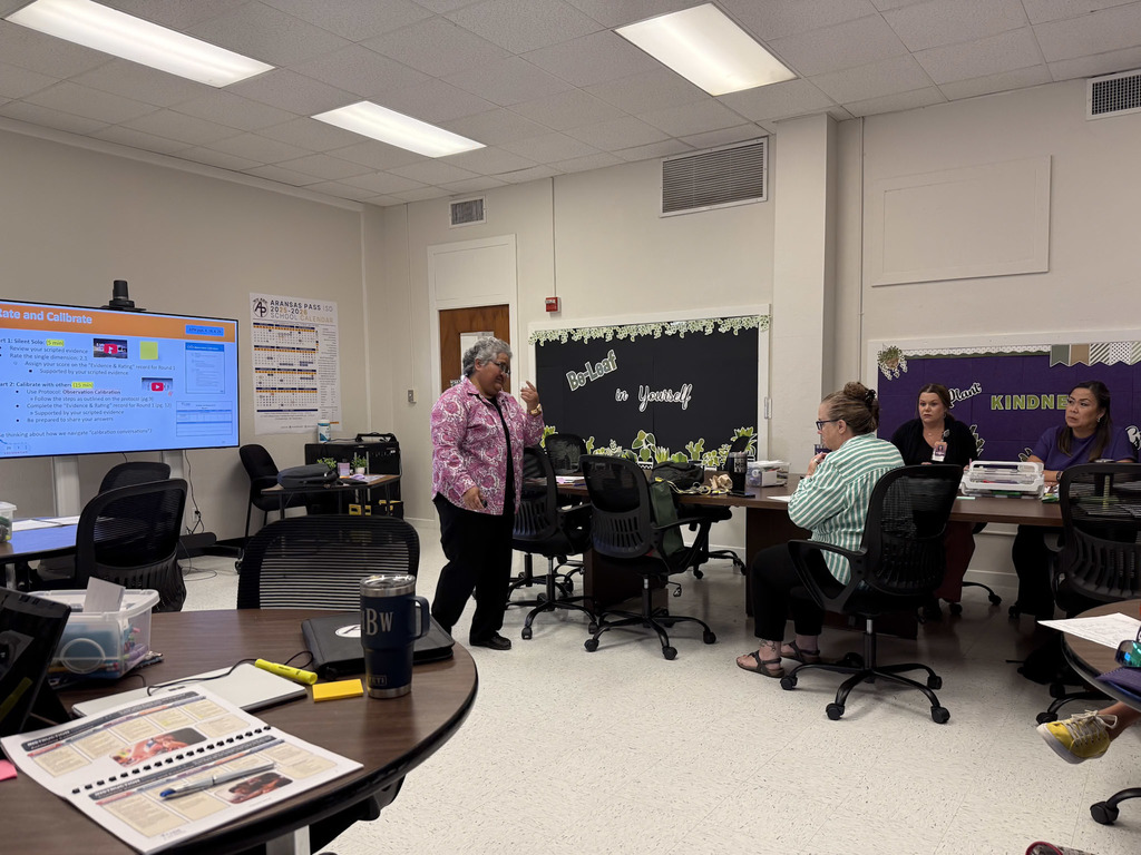 Person standing in front of a group of adults in a training room