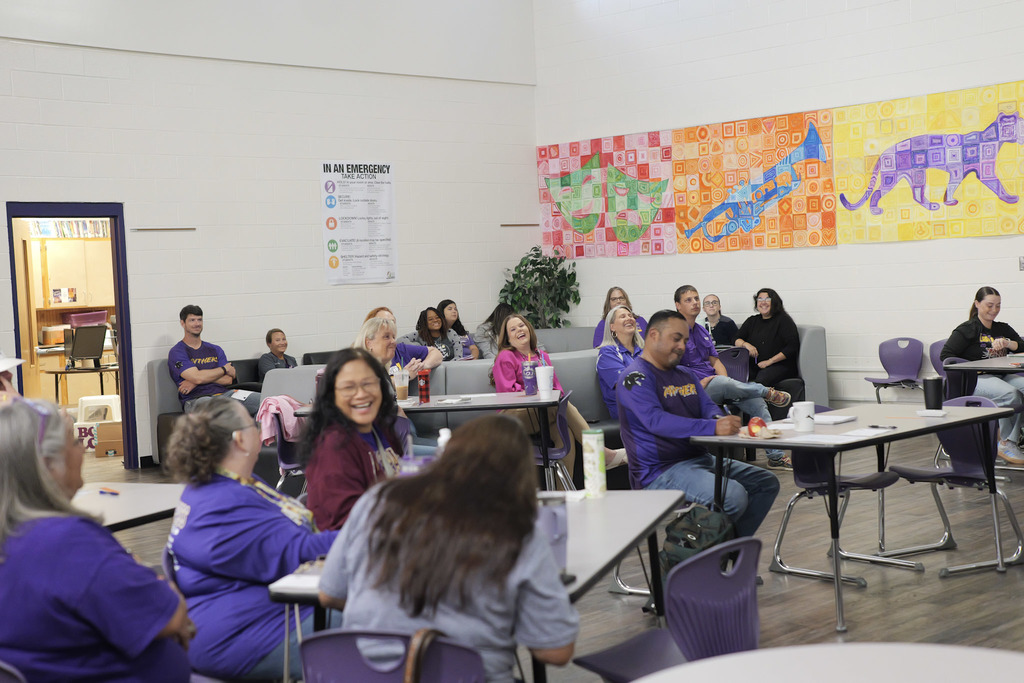 Group of teachers sitting in a meeting room, laughing