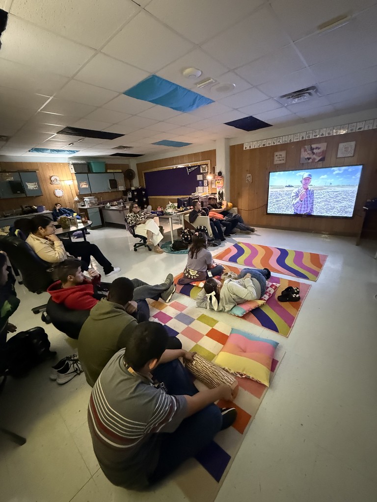 Students seated around a smart TV virtually meeting with a farmer