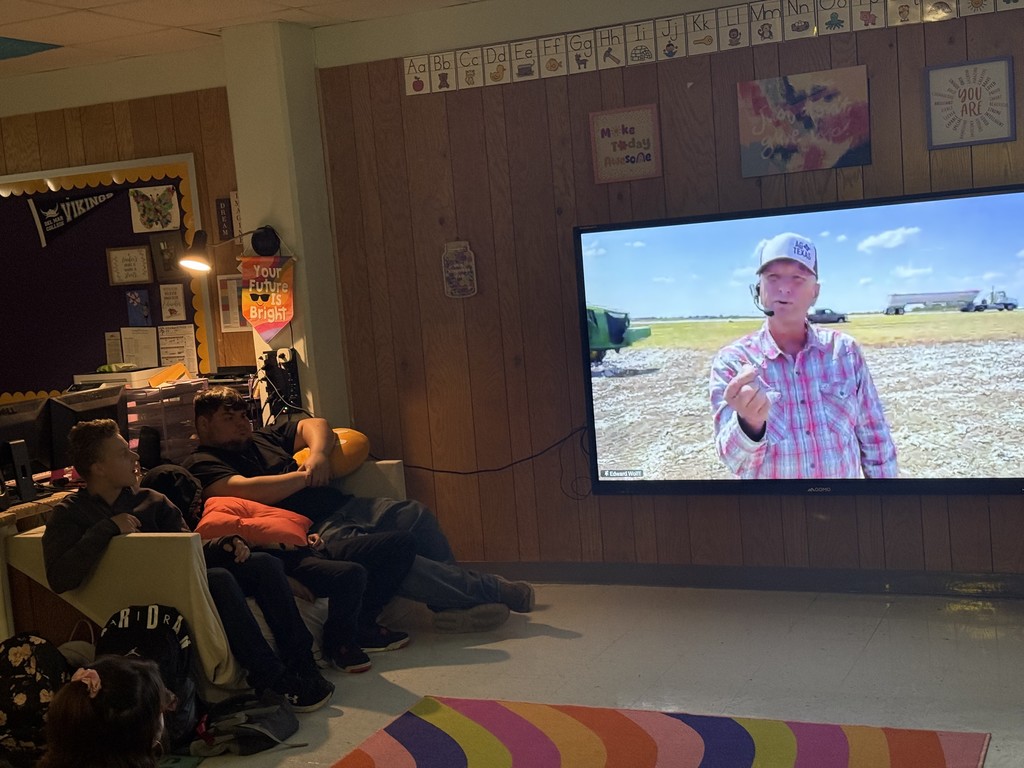 Students seated around a smart TV virtually meeting with a farmer