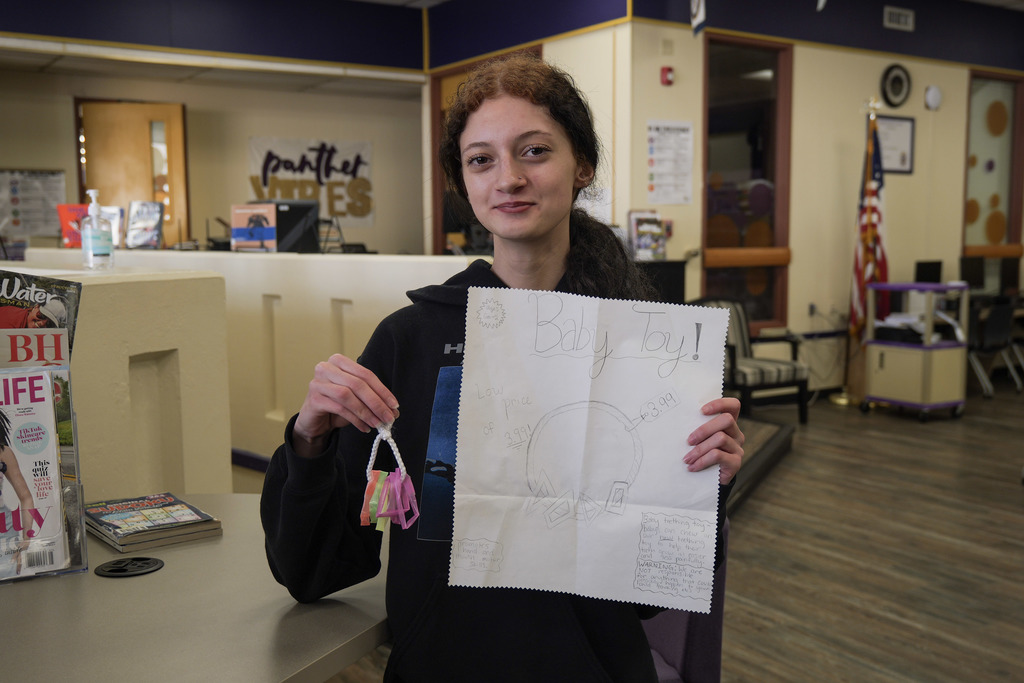 one female student holding a prototype of a toy