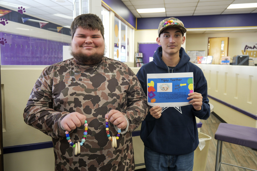 two male students holding prototypes of toys