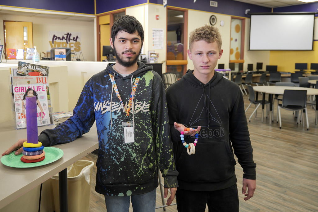 two male students holding prototypes of toys