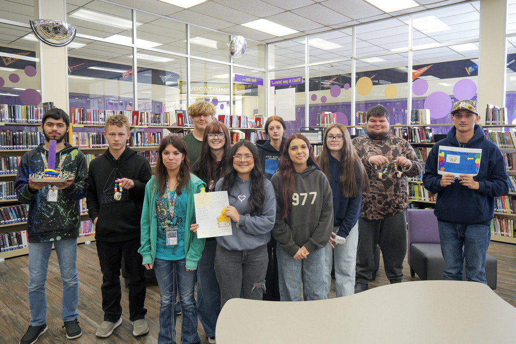 group of students in a library holding projects