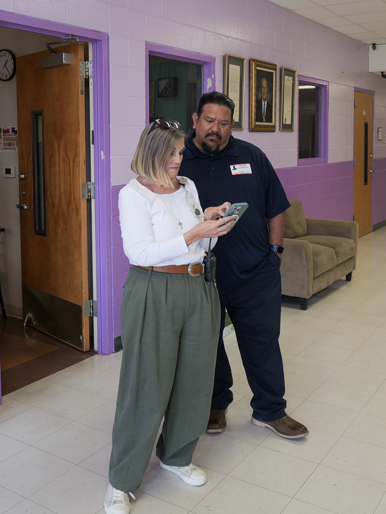 Two people looking at a cell phone.