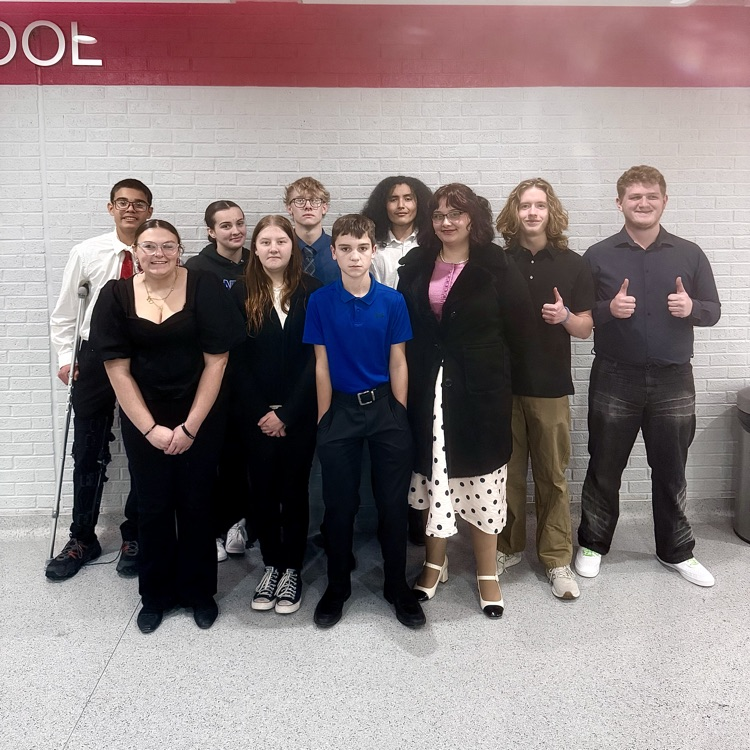 speech team in front of brick wall indoors