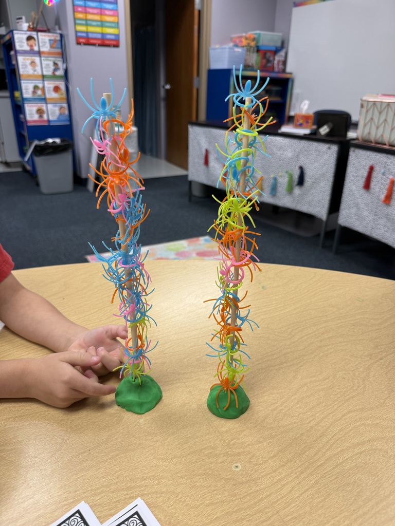 plastic spiders stacked on a wooden dowel
