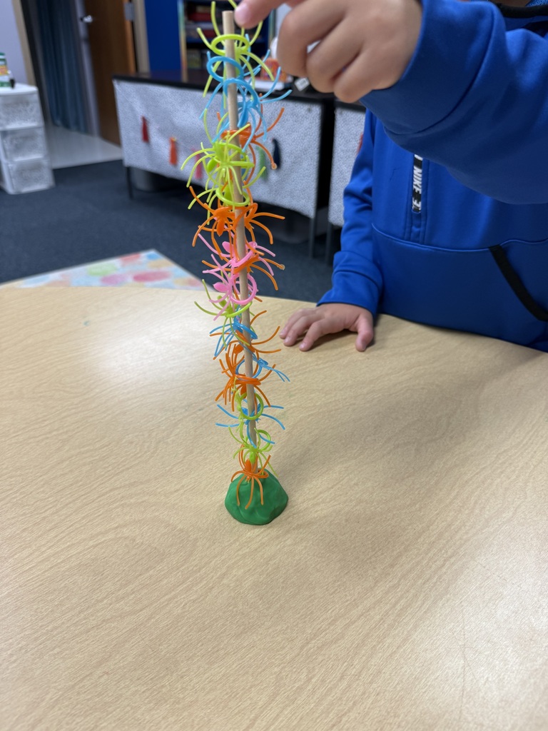 plastic spiders stacked on a wooden dowel