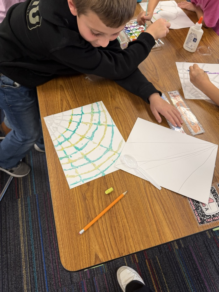 Students drew a web, covered it with glue and salt, then painted with watercolor.