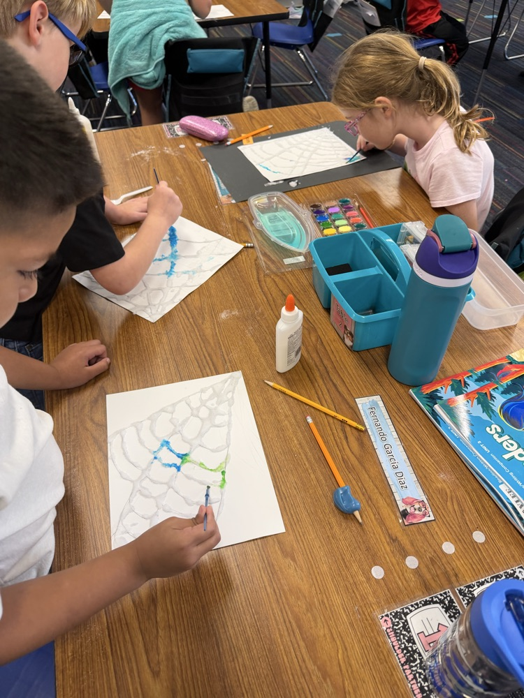 Students drew a web, covered it with glue and salt, then painted with watercolor.