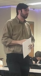 High school science teacher preparing to hand out resources to his students.