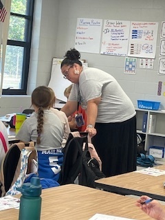 Elementary math teacher works with a student on finding equations that create the same fraction.