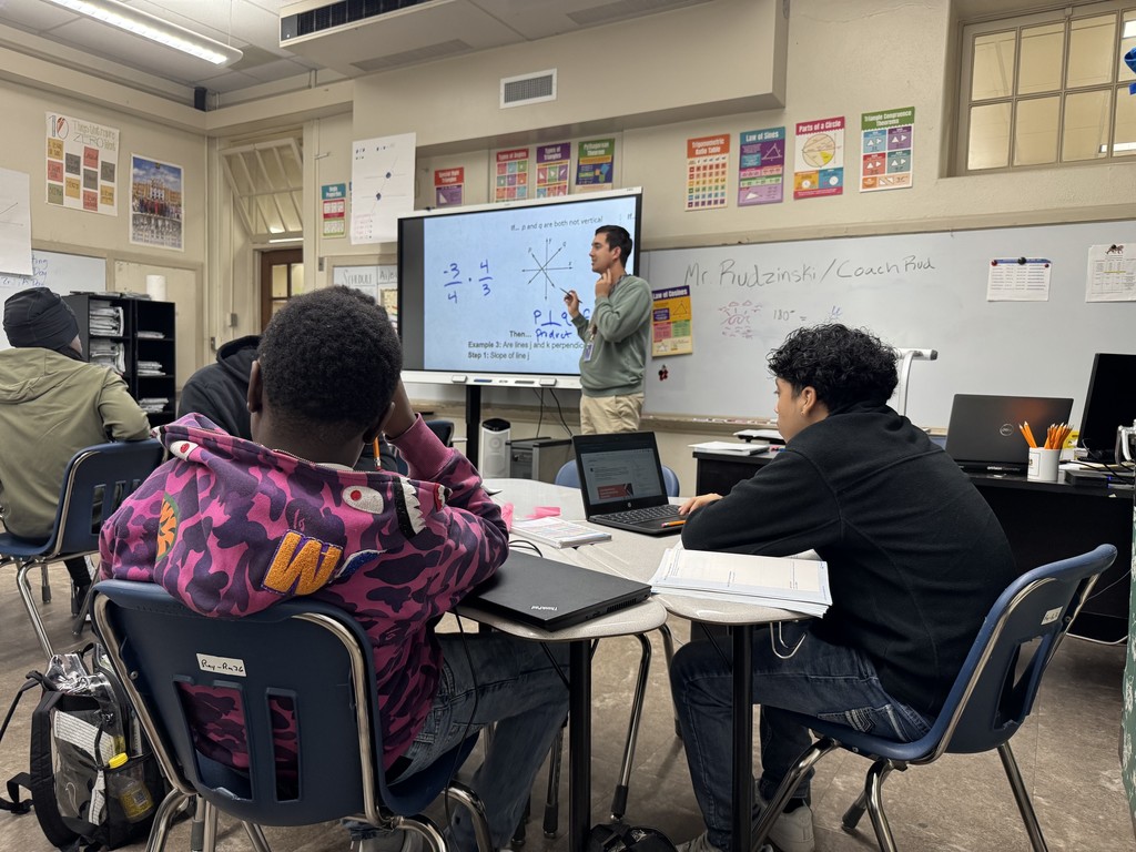 Teacher presenting a lesson with students listening.