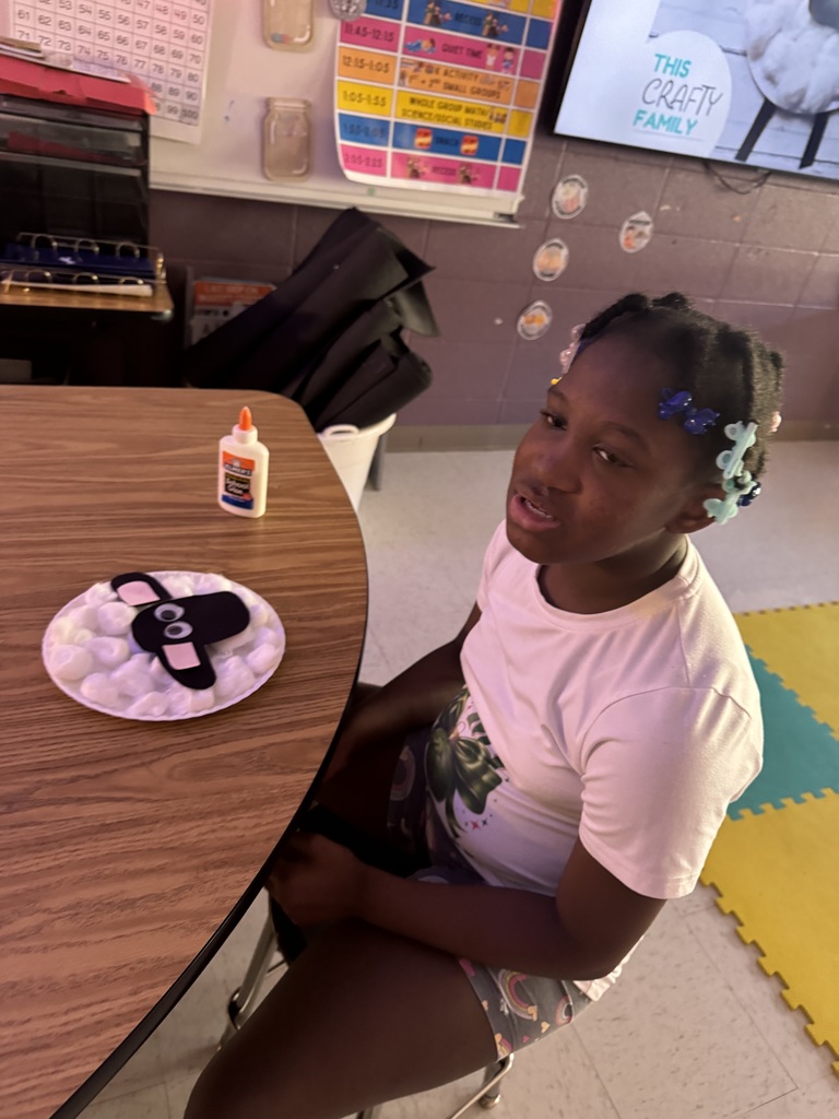 Student showing off a lamb made of cotton balls.