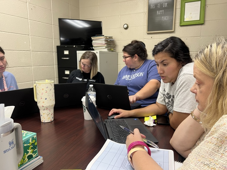teachers sitting around table collaborating.  