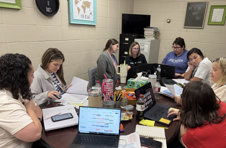 teachers sitting around table collaborating.  