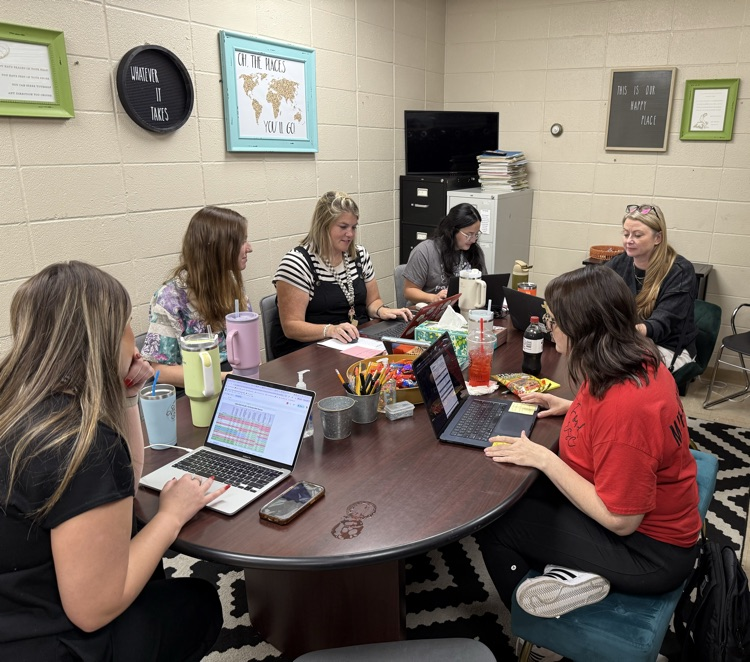 teachers sitting around table collaborating.  