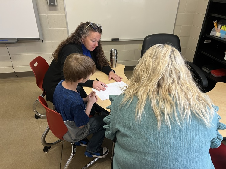 teachers working on math at table with student  