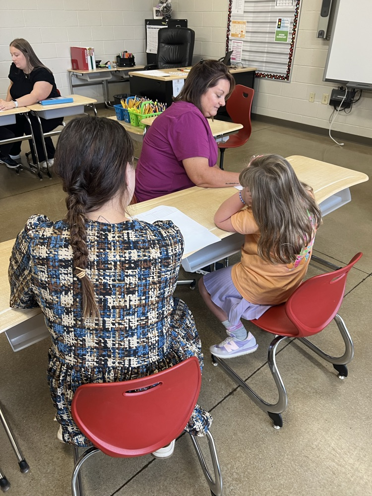 teachers working on math at table with student. 