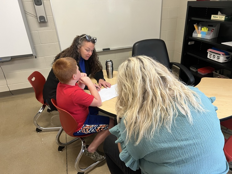 teachers working on math at table with student. 